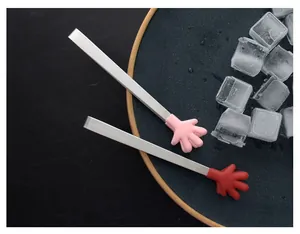 Creative mini silicone tongs with hand-shaped tips for ice cubes on black plate
