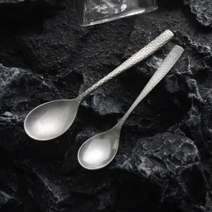 Vintage hammered matte 304 stainless steel coffee and dessert spoons on rock background