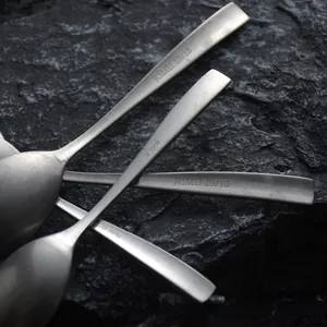 Vintage matte 18/10 stainless steel dessert spoons presented on dark stone background.