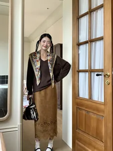 Stylish model wearing a vintage floral printed triangular scarf with a brown sweater