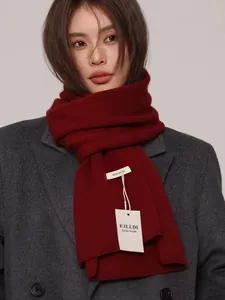 High-quality detail of a burgundy 100% Australian wool knitted scarf with ILLDI tags.
