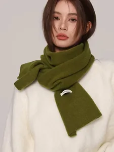 Detail of high quality 100% Australian wool knitted scarf in olive green worn by a model