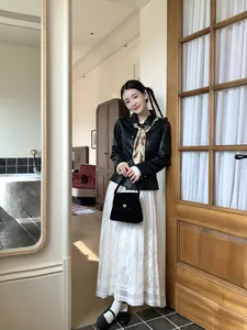 Model wearing a vintage floral printed triangle silk scarf and holding a black velvet handbag