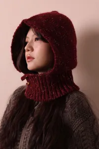 Close-up detail of a vintage burgundy knitted hooded scarf with a stylish horn button closure
