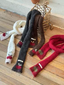 Close-up shot of narrow knit scarves in multiple colors featuring cute cherry patterns