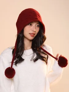 Detailed view of red wool knit elf hat with pom poms on a female model