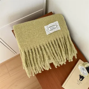 Close-up of sage green mohair scarf showing soft fuzzy texture and tassel fringe