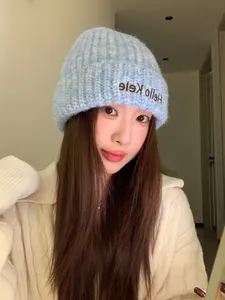 Close-up of a model wearing a soft light blue knitted beanie for cozy winter warmth