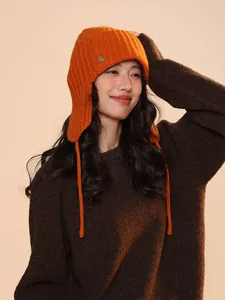 Close-up detail of women's orange 100% wool knit balaclava hat with earflap design