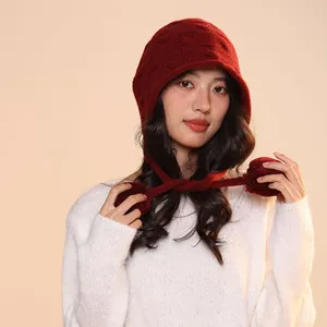 Macro detail of a burgundy pure wool knitted elf hat with hanging pom-poms on model