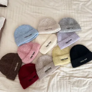 Soft knitted beanies in various colors with Hello Kele embroidery detail.