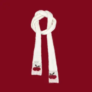 Detailed view of white knitted skinny scarf featuring red cherry motifs on ends