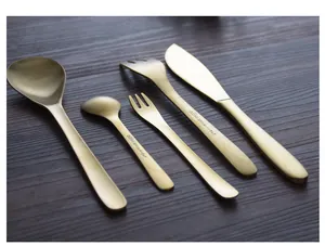 Detailed view of a 5-piece retro gold 304 stainless steel cutlery set on wood.