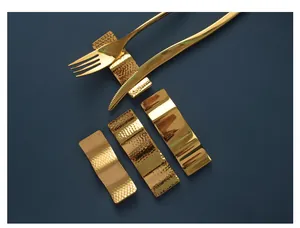 Detailed view of gold stainless steel cutlery rests with hammered and smooth textures.