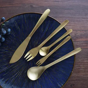 Retro gold 304 stainless steel cutlery set with willow leaf design on blue plate.