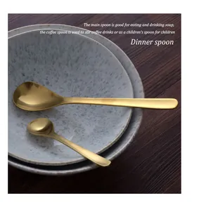Detail view of two gold stainless steel spoons on ceramic bowls for dinner and coffee