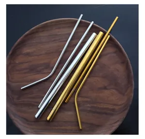 Detail view of 304 stainless steel straw set in gold and silver on a wooden plate