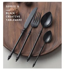 Macro detail of elegant black bamboo-joint stainless steel cutlery set on wooden plate