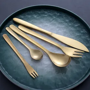 5-piece gold 304 stainless steel cutlery set with retro willow leaf design on green plate