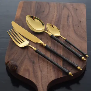 Luxury black and gold 304 stainless steel cutlery set with mirror finish on wooden board