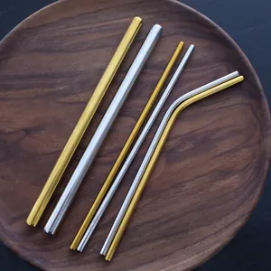 Reusable 304 stainless steel straw set in gold and silver on a round wooden plate