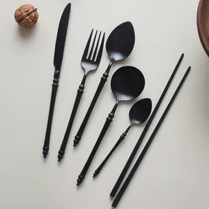 Elegant matte black stainless steel cutlery set with knife fork spoons and chopsticks.