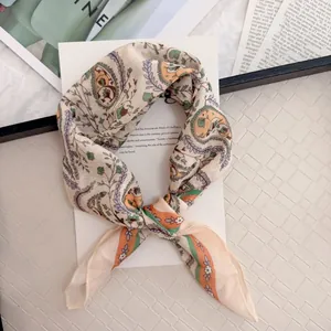 Macro view of vintage paisley floral pattern on a soft cotton linen square neck scarf.