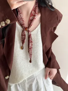 Nahaufnahme einer Vintage Paisley Seidenschal-Halskette mit Bernsteinperlen