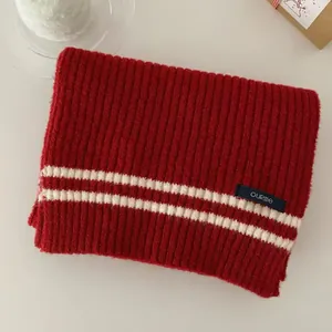 Detailed view of soft red knitted academy style scarf featuring white stripes texture