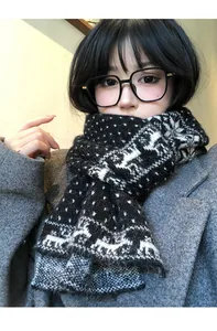Primo piano di una spessa sciarpa in maglia a fiocchi di neve indossata da una modella