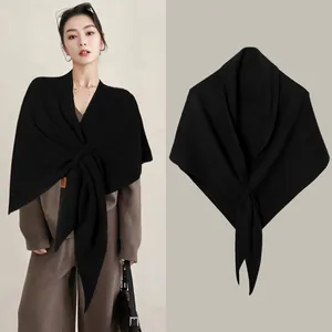 Elegant black wool blend cross-knit shawl cape shown on model and in a flat lay view