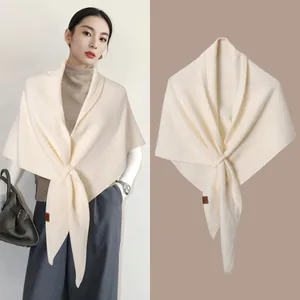 Detail view showing a cream wool blend knit shawl on an Asian model and as a studio flat lay