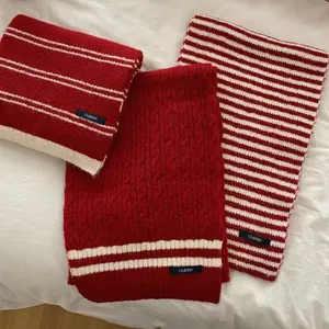Close-up of three retro red and cream striped scarves featuring cable knit textures
