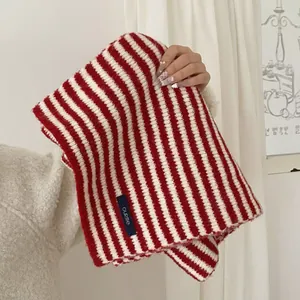 Detailed close-up of a warm red and white striped knitted scarf in preppy college style