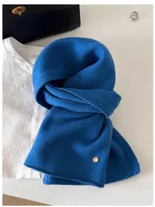 Close-up detail of soft blue 100% wool knit scarf styled with classic fashion props