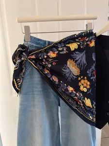 Detailed view of floral triangle scarf used as a stylish waist tie accessory on denim jeans.