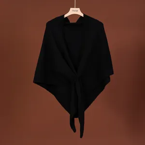 Close-up detail of a soft black wool blend knit shawl with elegant crossover design
