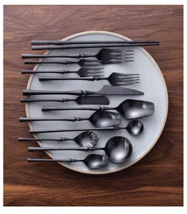 Detail view of premium matte black 304 stainless steel cutlery set on a ceramic plate