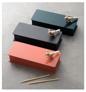Detail view of creative stainless steel toothpick boxes with a golden bird ornament
