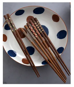 Close-up of Japanese style wooden chopsticks with colorful patterns on a polka dot plate