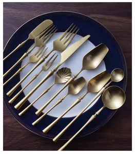 Detailed view of 304 stainless steel matte gold cutlery set on a blue patterned plate