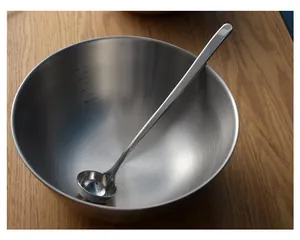 Detailed view of 304 stainless steel long-handled measuring spoon inside a mixing bowl