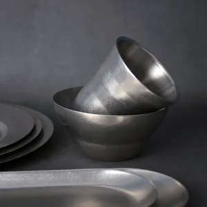 Japanisches Vintage-Tafelgeschirr-Set aus mattem Edelstahl mit Schüssel, Tasse und Tellern.