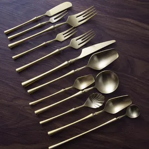 Matte gold 304 stainless steel cutlery set with slim waist handles on wooden table