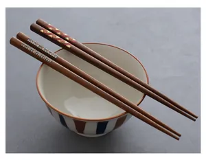 Detailed view of Japanese style wooden chopsticks with colorful woven patterns on ceramic bowl