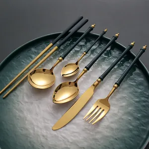 Elegant emerald green and gold 304 stainless steel cutlery set on a textured plate