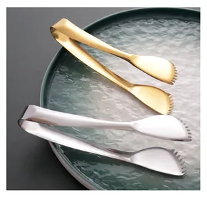 Detail view of gold and silver 304 stainless steel food tongs with serrated edges for serving