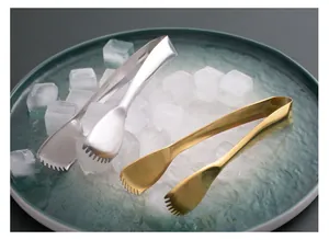 Detail view of gold and silver 304 stainless steel serrated ice tongs on a bed of ice