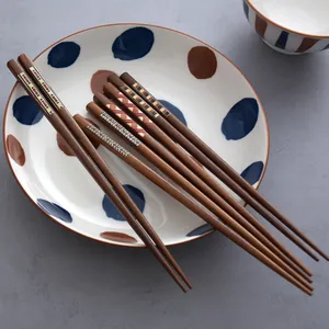 Elegant Japanese-style wooden chopsticks with colorful geometric patterns on a polka dot plate