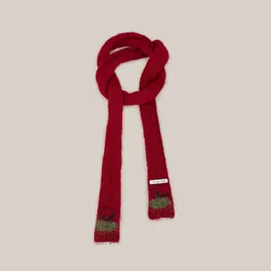Detailed view of red thin knitted scarf featuring charming cherry pattern embroidery